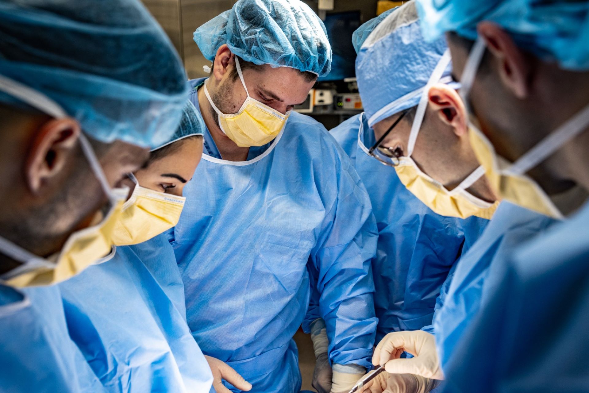 Ορθοπεδικοί χειρουργοί και νοσηλευτές που φορούν ιατρική ενδυμασία εκτελούν μια επέμβαση.