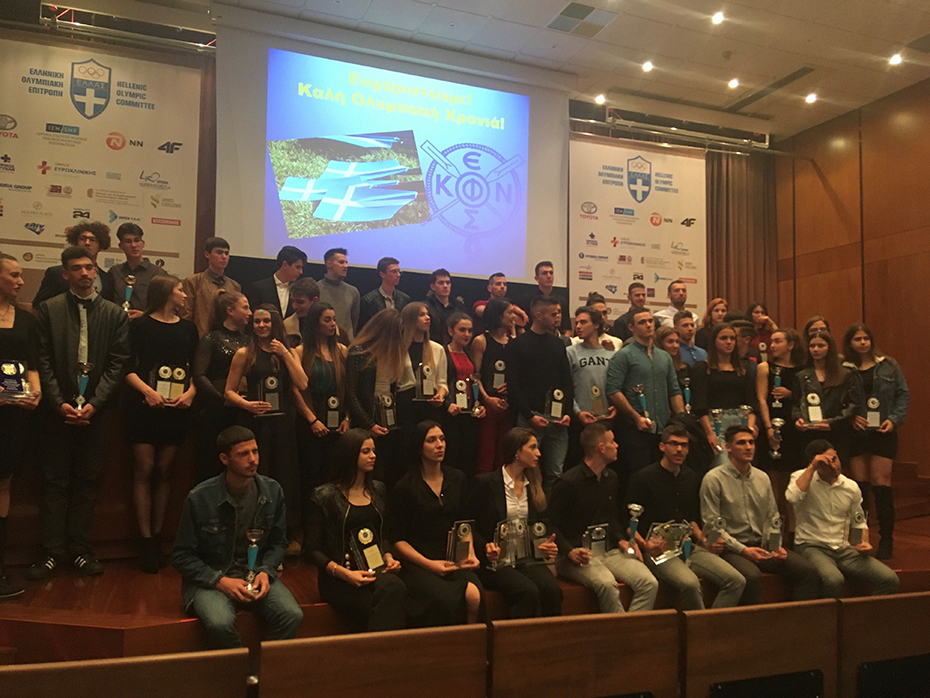 Πλήθος νέων κρατούν στα χέρια τους βραβεία και στέκονται για μια αναμνηστική φωτογραφία 