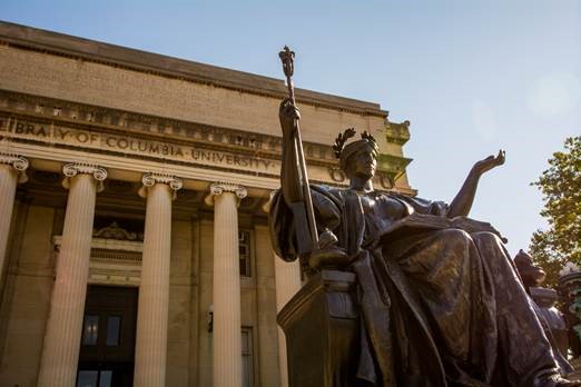 Ένα χάλκινο άγαλμα μιας γυναίκας με ένα βιβλίο με τα χέρια της ανοιχτά, μπροστά από τη βιβλιοθήκη του Πανεπιστημίου Κολούμπια