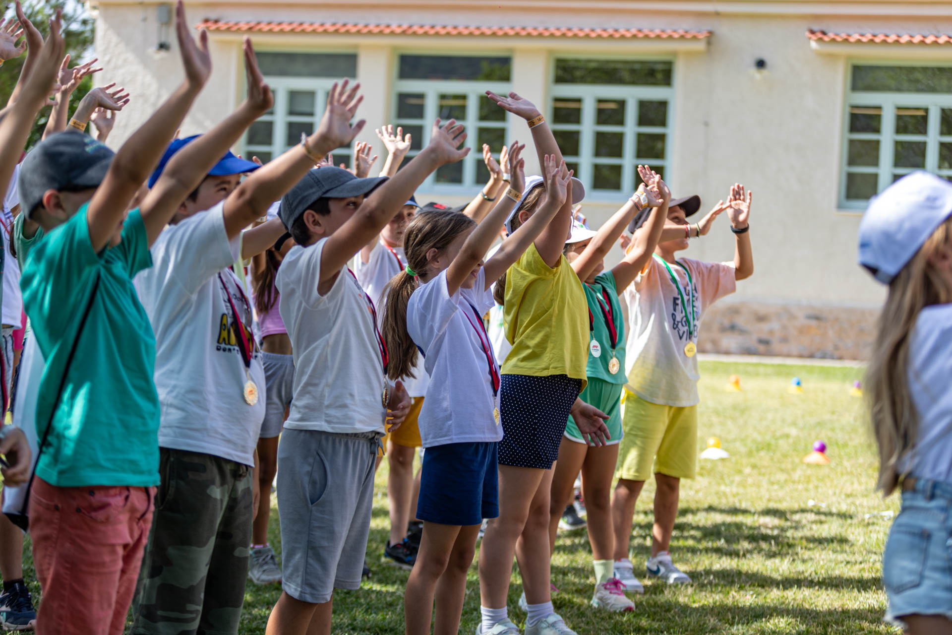 Μία ομάδα παιδιών σηκώνουν τα χέρια τους ψηλά 
