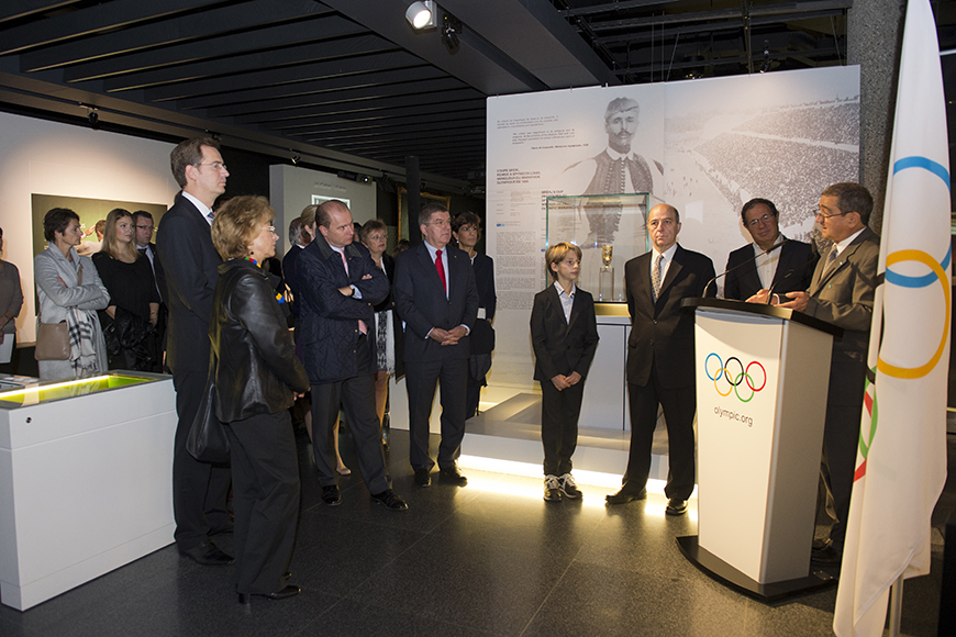 Κόσμος παρακολουθεί έναν άντρα ο οποίος βγάζει λόγο στο βήμα των Ολυμπιακών Αγώνων