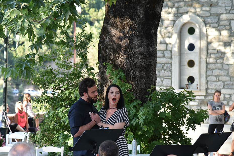 Ένας άντρας ακουμπάει στο στήθος του το χέρι μιας γυναίκας η οποία τραγουδάει 