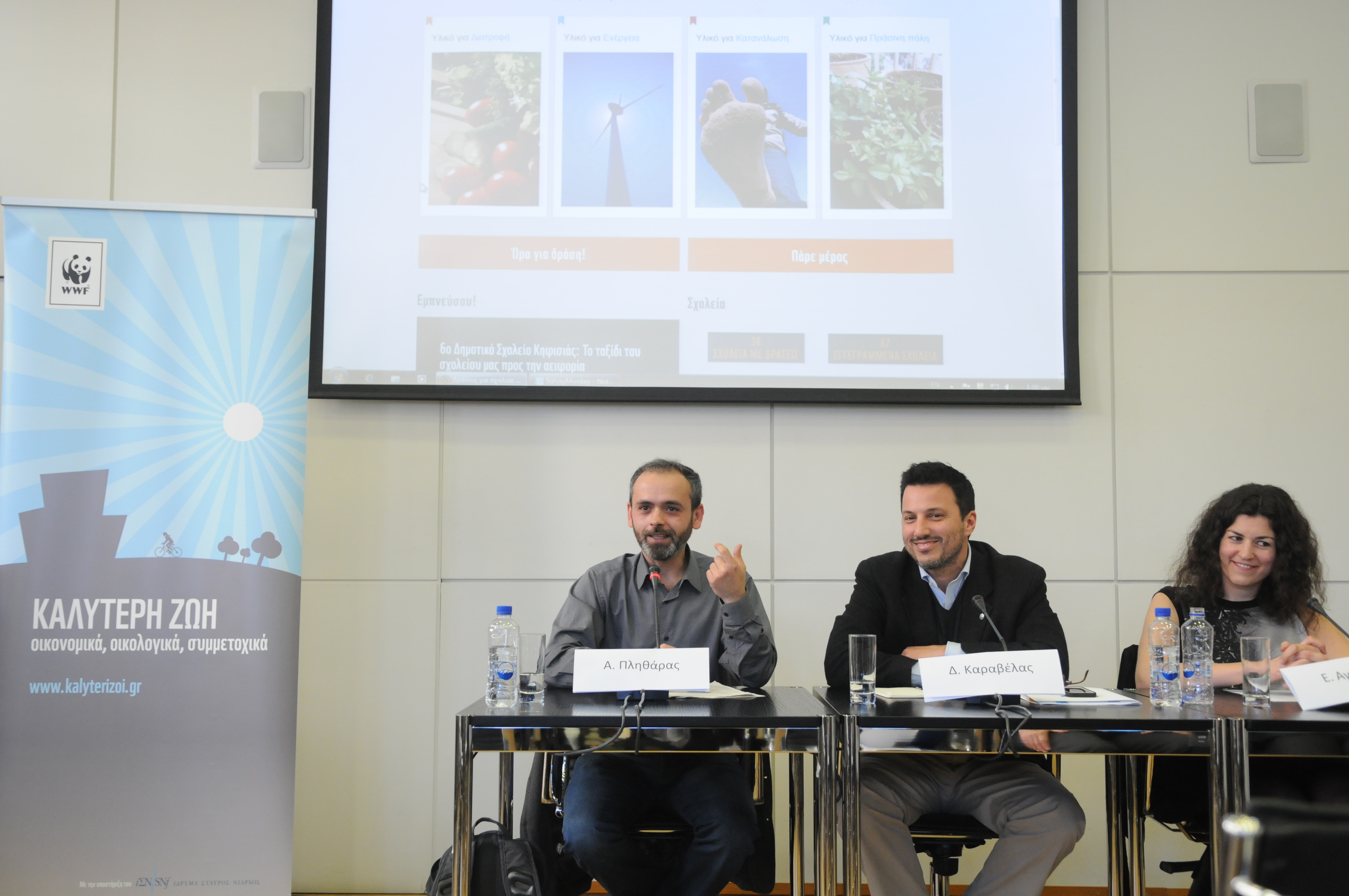 Τρία άτομα κάθονται σε ένα τραπέζι συνεδριάσεων και κάνουν μια παρουσίαση