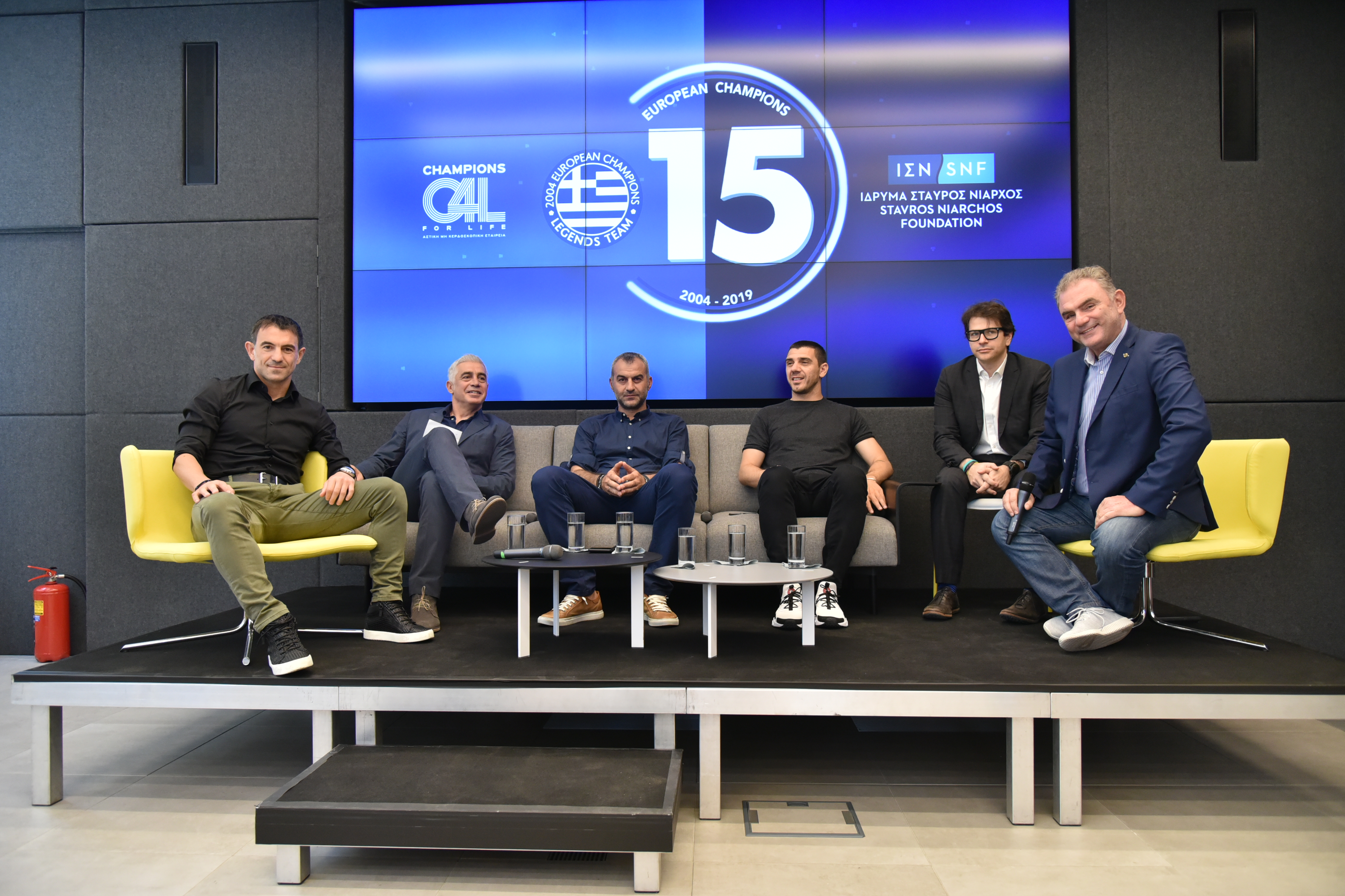 Έξι άντρες κάθονται και χαμογελούν για μια αναμνηστική φωτογραφία 