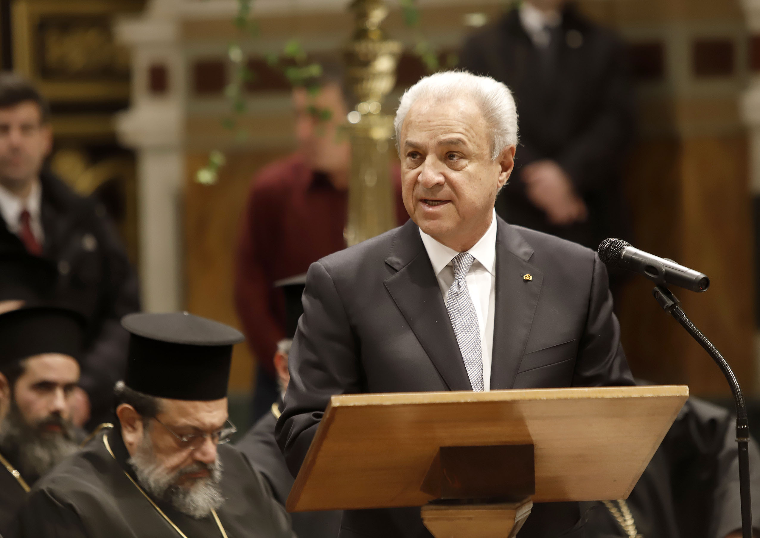 Ένας άνδρας μιλάει  σε μια εξέδρα του Ιερού Καθεδρικού Ναού της Μητρόπολης Αθηνών