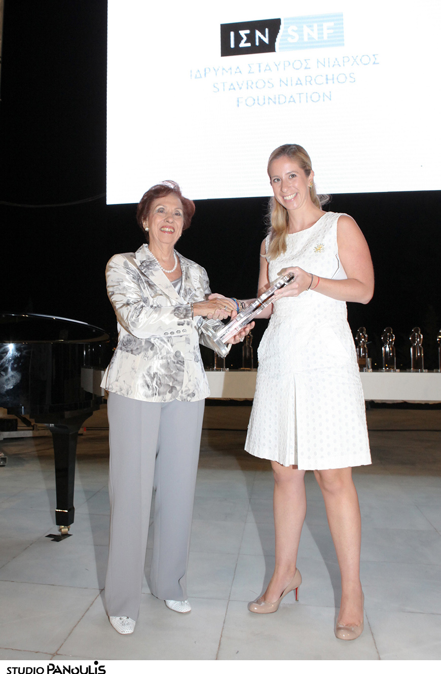 Μέλος του Ιδρύματος Σταύρος Νιάρχος χαμογελά καθώς παραλαμβάνει βραβείο εκ μέρους του Ιδρύματος Σταύρος Νιάρχος