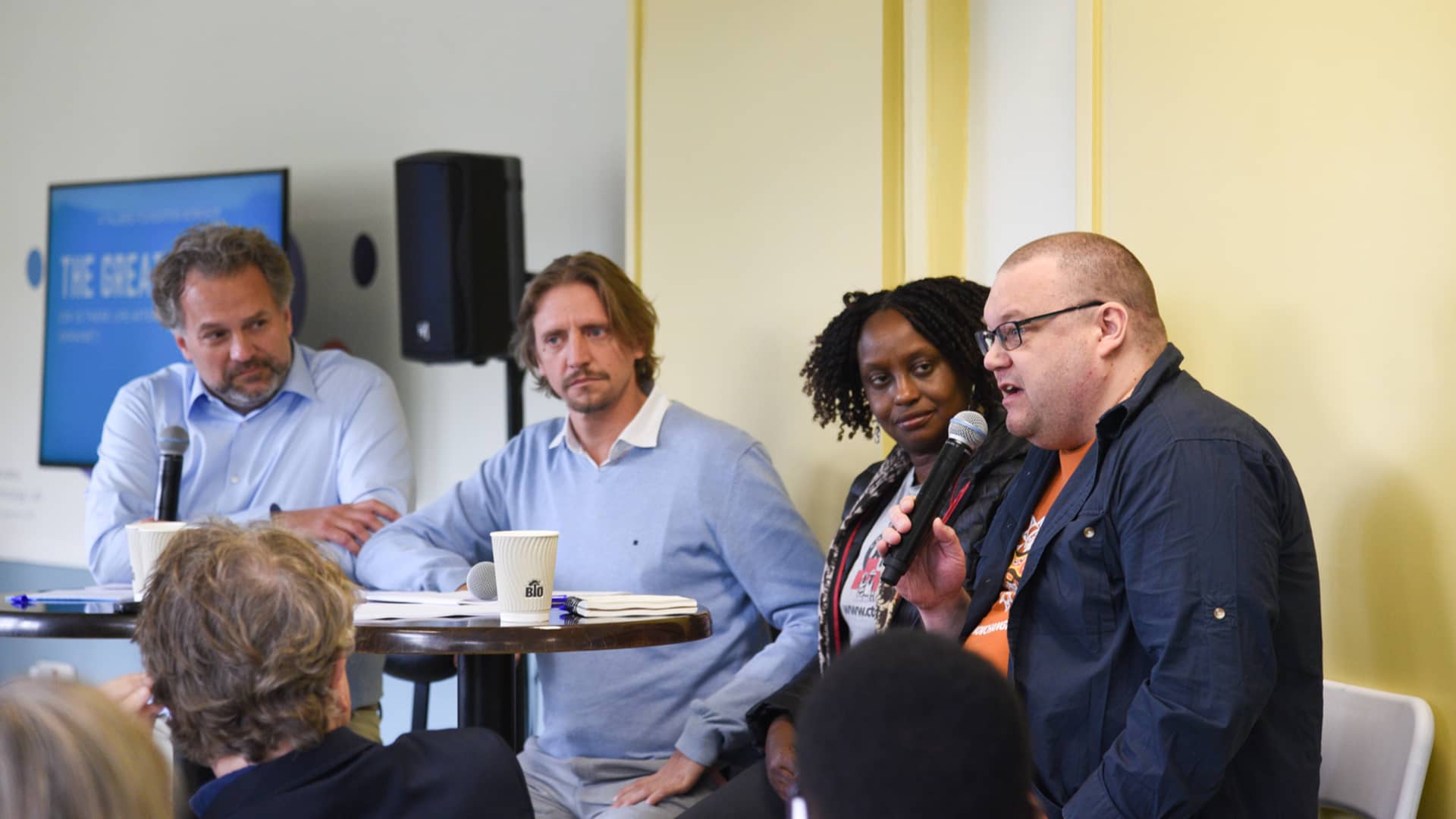 Τέσσερις άνθρωποι κάθονται δίπλα και απευθύνονται στο κοινό που τους παρακολουθεί 