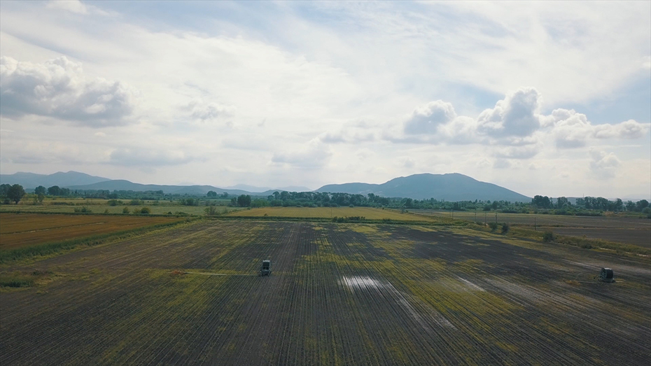 Δύο αγρότες με γεωργικούς ελκυστήρες εργάζονται σε ένα αγρόκτημα