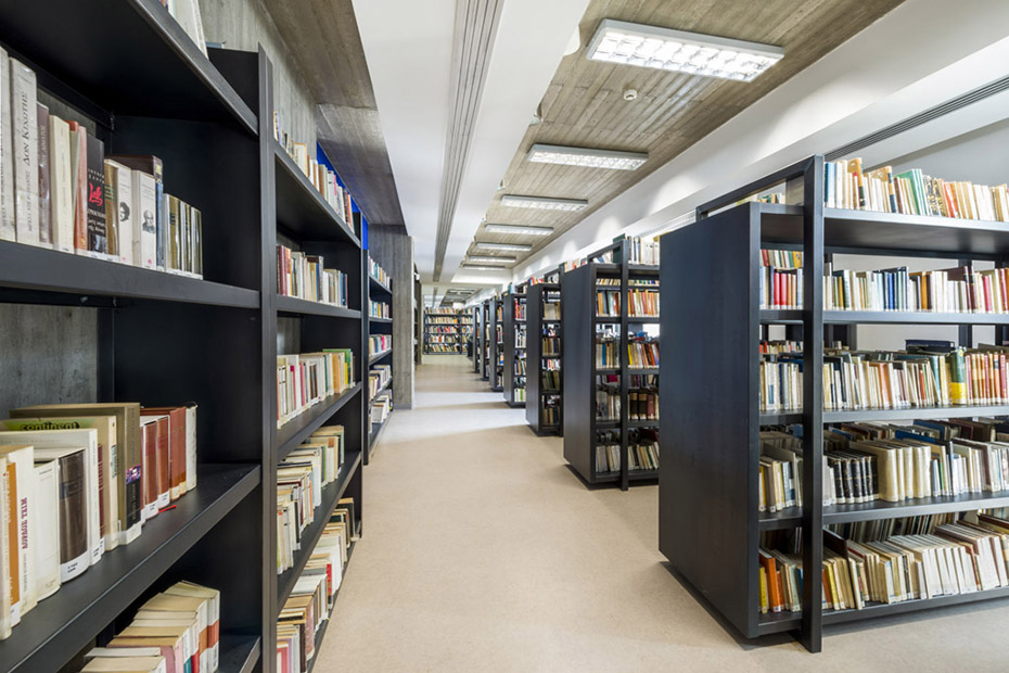 Μια φωτογραφία που δείχνει τον εσωτερικό χώρο μιας βιβλιοθήκης, με πολλά ράφια γεμάτα βιβλία 