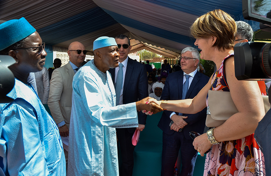 Ένας άντρας και μια γυναίκα κάνουν χειραψία και ο κόσμος γύρω τους τους κοιτά 