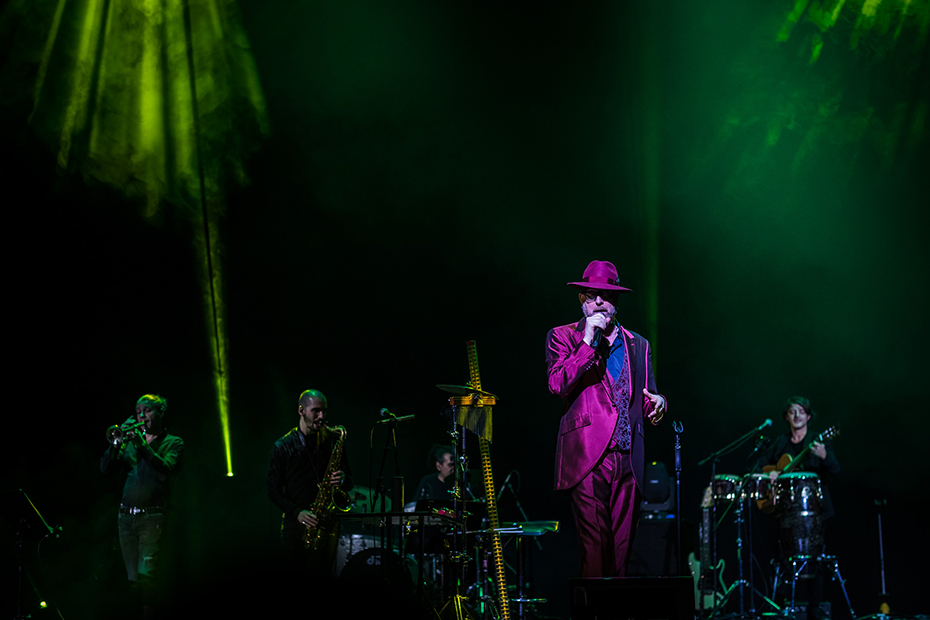 Ένας τραγουδιστής πάνω στη σκηνή, συνοδευόμενος από μια μπάντα