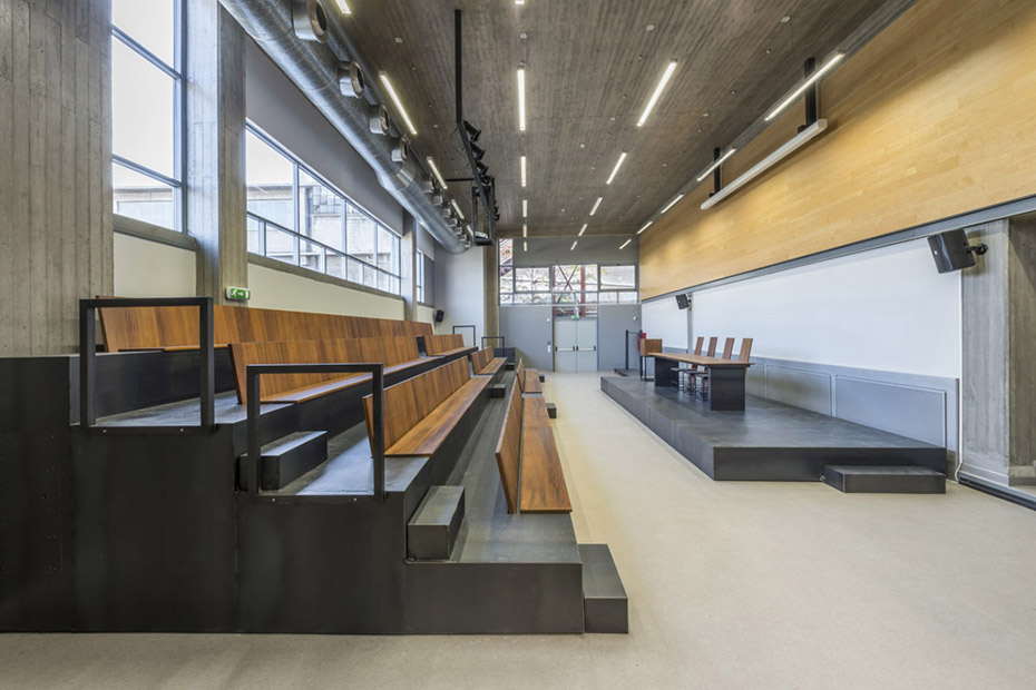 Φωτογραφία που δείχνει ένα μικρό αμφιθέατρο το οποίο έχει θέσεις σαν κερκίδες και μια σκηνή στην οποία υπάρχει ένα γραφείο με καρέκλες 