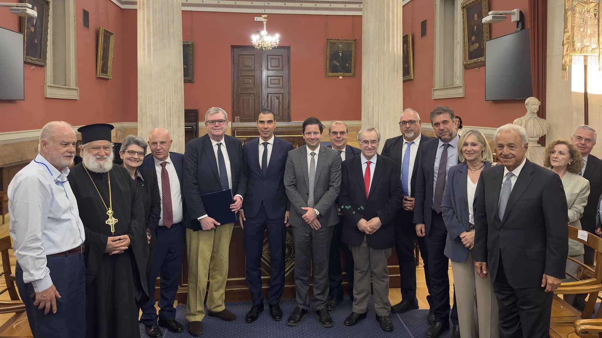 Μια ομάδα ανθρώπων που στέκονται σε ένα δωμάτιο και ποζάρουν για μια φωτογραφία. 