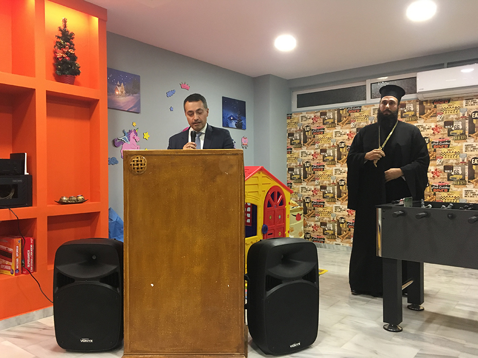 Μέλος του Ιδρύματος Σταύρος Νιάρχος δίνει ομιλία ενώ δίπλα του στέκεται ο πάτερ Βλάσιος