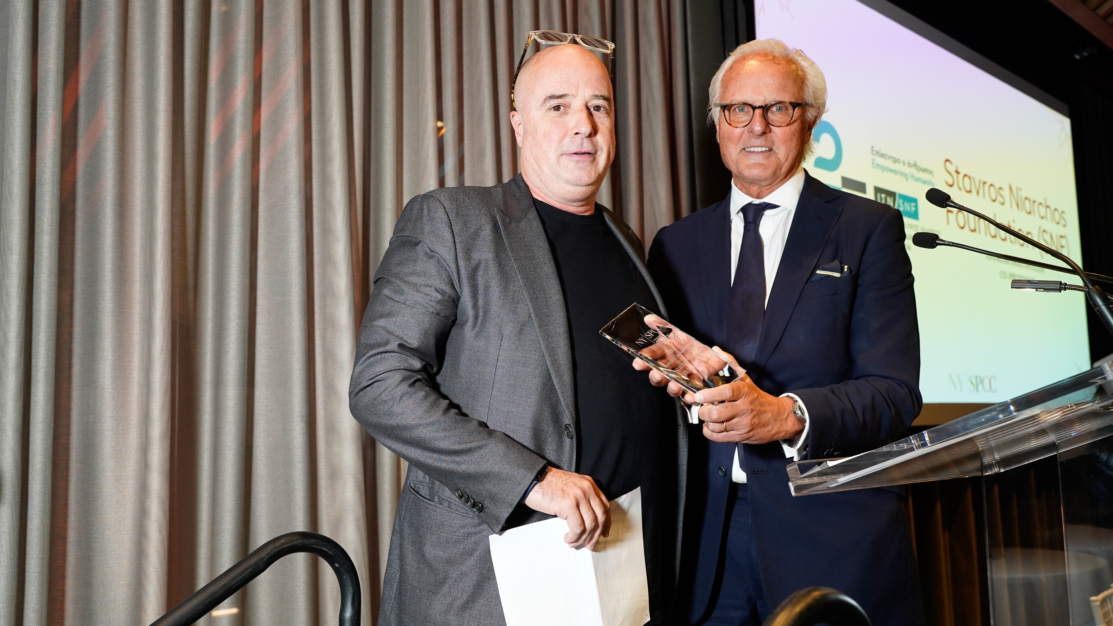 Ο Αντρέας Δρακόπουλος, Πρόεδρος του Ιδρύματος Σταύρος Νιάρχος, δέχεται το τιμητικό βραβείο του και φωτογραφίζεται με επίτημο μέλος του οργανισμού New York Society for the Prevention of Cruelty to Children (NYSPCC)