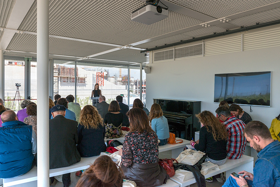 Μια γυναίκα δίνει ομιλία μπροστά σε καθιστό κοινό