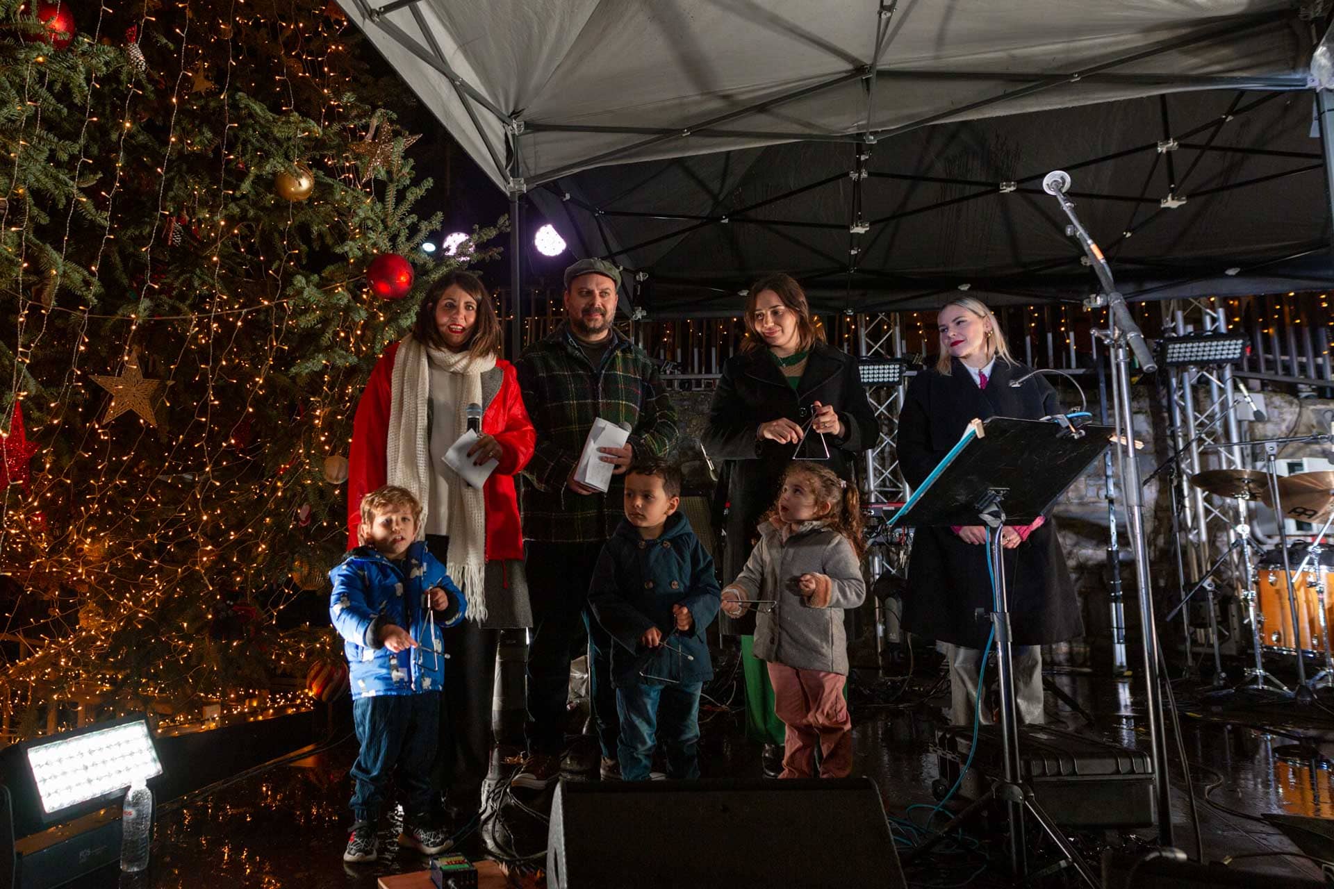 Μέλη της ομάδας της Vamvakou Revival, και μια εκπρόσωπος του ΙΣΝ, μαζί με τρία παιδιά στη σκηνή.