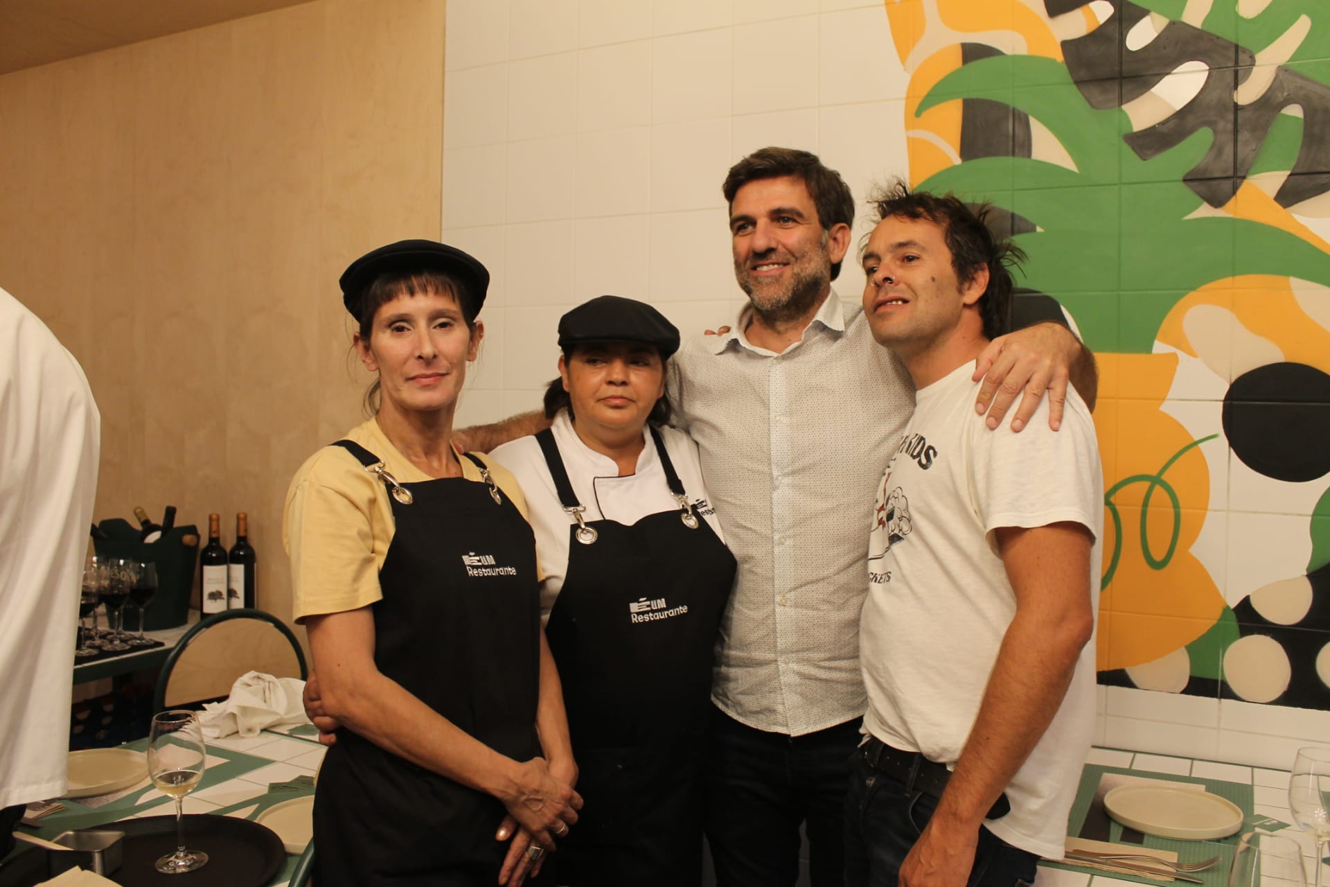 Δύο άντρες αγκαλιάζουν δύο άτομα που δουλεύουν στο É Um Restaurante