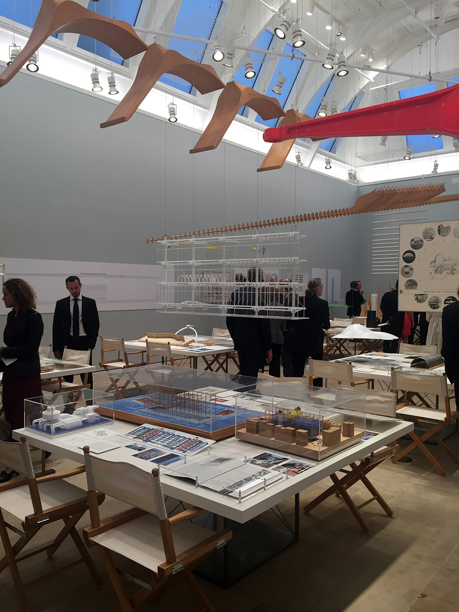 Ένας χώρος με τετράγωνα τραπέζια πάνω στα οποία υπάρχουν μακέτες οι οποίες δείχνουν διαφόρων ειδών κτήρια 