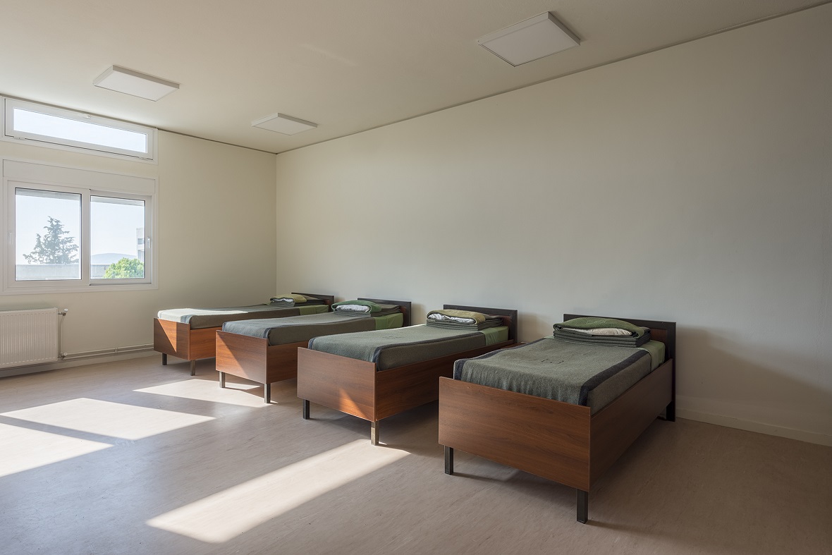 Τέσσερα κρεβάτια σε ένα δωμάτιο με παράθυρο και φυσικό φως