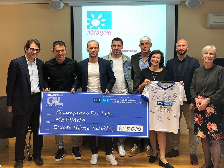 Η ομάδα των Πρωταθλητών Ευρώπης, Legends 2004, μαζί με μέλη του Ιδρύματος Σταύρος Νιάρχος, κρατώντας μια μεγάλη επιταγή από το 