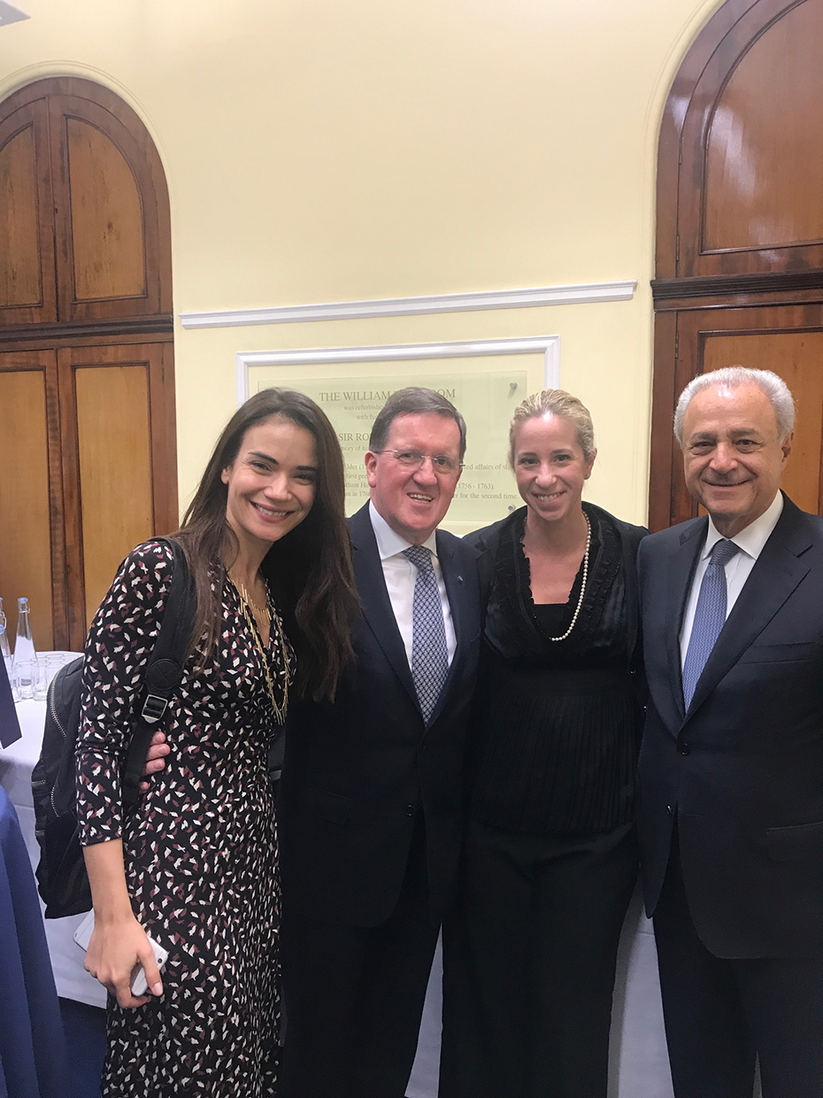 Δύο άντρες και δύο γυναίκες στέκονται αγκαλιασμένοι για μια αναμνηστική φωτογραφία 